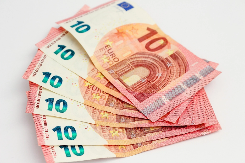 Billets de dix euros étalés en éventail sur une surface blanche